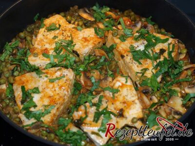 Die fertigen Thunfischfilets auf Erbsen gegart und mit Petersilie bestreut