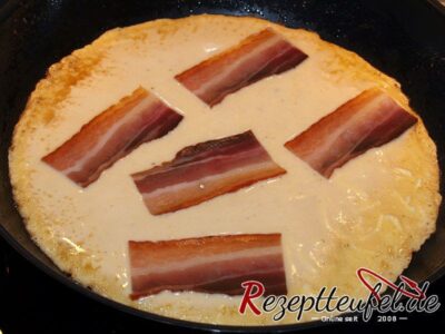 Der Speck kommt auf den Pfannkuchenteig