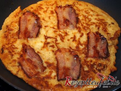 Der Speck wird mit dem Pfannkuchen ausgebacken