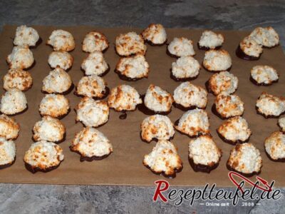 Die ausgekühlten Makronen werden mit dem Boden in Kuvertüre getaucht