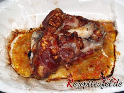 Die gegarte Schweinshaxe im aufgeschnittenen Bratschlauch