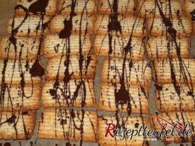Die Spritzgebäck-Plätzchen mit Kuvertüre besprenkelt