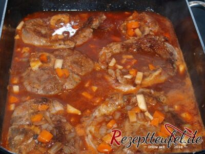 Die Beinscheiben in das mit Wein und Brühe aufgegossene Gemüse geben