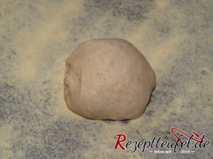 Leicht rund geformtes Teigstück auf der mit Grieß bestreuten Arbeitsfläche