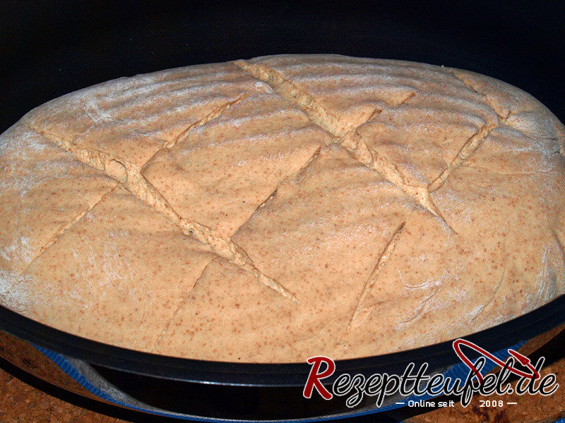 Der Brotteig ist in den heißen Bräter gestürzt und eingeschnitten