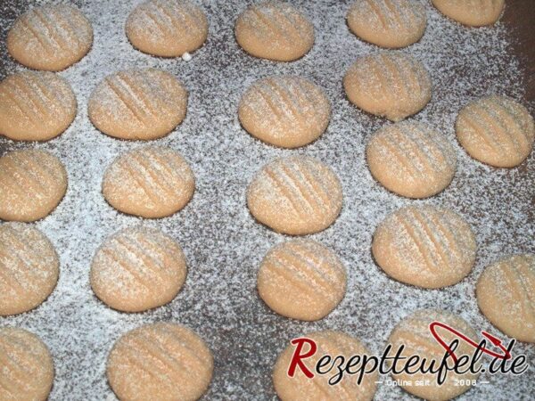 Die gebackenen Schneeflocken-Plätzchen nach dem Backen mit Puderzucker bestäuben