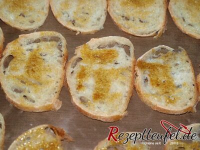 Baguettescheiben mit dem gewürzten Öl vor dem Backen