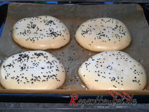 Aufgegangene Teiglinge mit Milch bestrichen und Kreuzkümmel bestreut