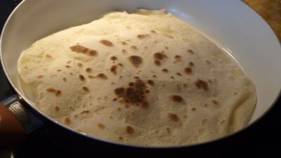 Der Teigfladen wird in einer Pfanne zum Tortilla-Wrap gebacken.